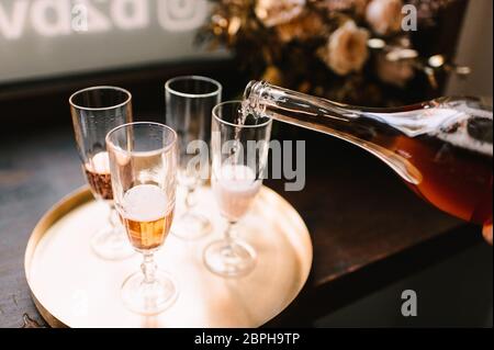 Vier Gläser mit Champagner stehen auf einem goldenen Tablett Stockfoto