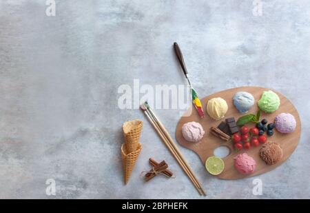 Verschiedene Eisbecher auf einer Malerpalette mit Zutaten in der Mitte Stockfoto