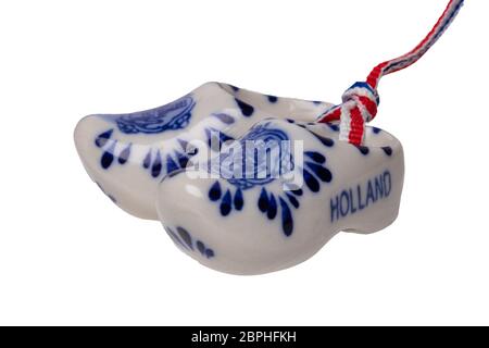 Holland Holzschuhe. Ein paar traditionelle niederländische Porzellan Schuhe mit einem Band Flagge mit weissem Hintergrund. Souvenir aus Amsterdam. Makro. Stockfoto