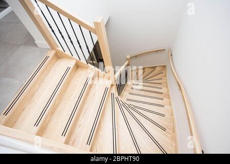 Luxuriöse moderne Holztreppe mit geschwungener Landewand in modernem Design Stockfoto