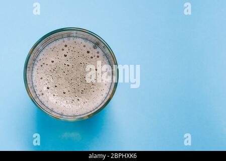 Glas mit Bier oder Mineralwasser auf blauem Hintergrund mit einer Kopie des Raumes. Alkoholisches oder alkoholfreies Erfrischungsgetränk. Ein Draufsicht auf ein Stockfoto