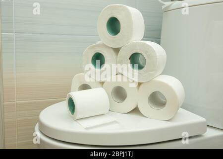 Die Pyramide von Toilettenpapier liegt auf dem Deckel der Toilette Stockfoto