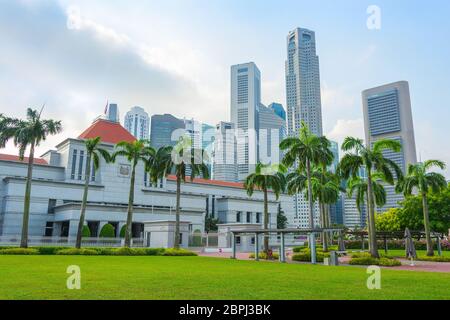 Singapur Parlament Gebäude, das von grünen Rasen, moderne Skyline im Hintergrund Stockfoto