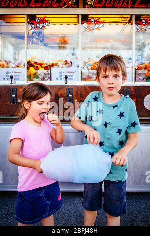 Foto von einem Bruder und Schwester essen eine grosse Zuckerwatte in einem Vergnügungspark. Stockfoto