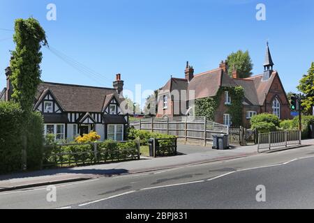 Ein traditionelles Englisg Holzhaus steht neben dem viktorianischen Schulhaus der Gresham Primary School im Dorf Sanderstead, Surrey. Stockfoto