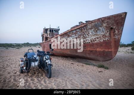 Farbe Bild eines Schiffswracks und einem beiwagen Motorrad auf dem ehemaligen Ufer des Aralsees in Moynaq, Usbekistan. Stockfoto