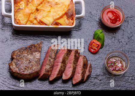 Steak in Scheiben mit Kartoffelgratin Stockfoto