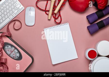 Weibliche Fitness Stillleben. Sporternährung (Ergänzungen), Sportzubehör, Computertastatur und Maus auf rosa Hintergrund. Modell. Draufsicht, Kopie en Stockfoto