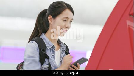 Frau, die am Check-in-Schalter am Flughafen Selfie benutzt Stockfoto