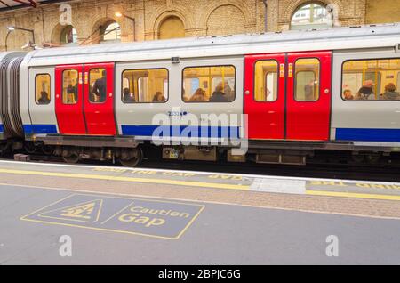 Farringdon, London, Großbritannien: 2. Dez 2017: Bahnsteige der Londoner U-Bahn haben Nachrichten auf dem Boden, die über die Lücke zwischen dem Zug und dem warnen Stockfoto