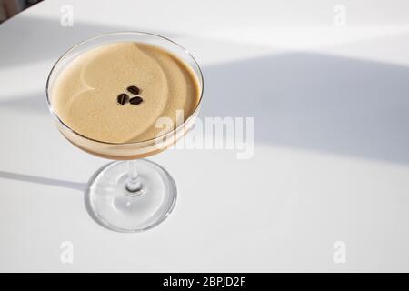 Eleganter Kaffee-Cocktail auf weißem Tisch bei natürlichem Sonnenlicht Stockfoto