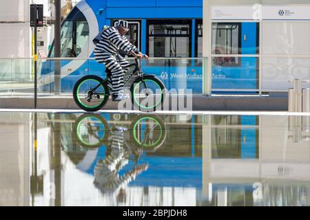 Birmingham, Großbritannien. Mai 2020. Ein stilvoll gekleideter Radfahrer fährt auf dem Centenary Square im Stadtzentrum von Birmingham um die Brunnen herum. Quelle: Peter Lopeman/Alamy Live News Stockfoto