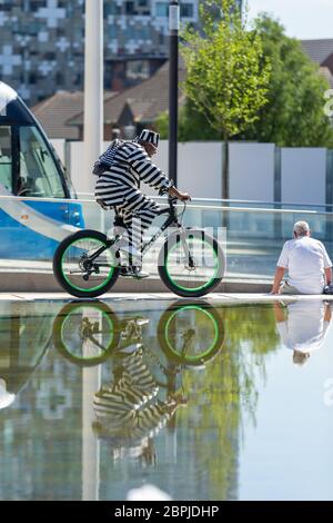 Birmingham, Großbritannien. Mai 2020. Ein stilvoll gekleideter Radfahrer fährt auf dem Centenary Square im Stadtzentrum von Birmingham um die Brunnen herum. Quelle: Peter Lopeman/Alamy Live News Stockfoto