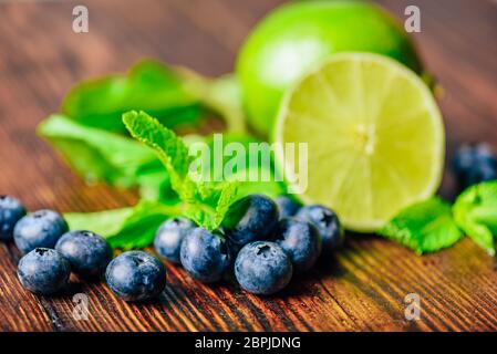 Frische Heidelbeeren, die Hälfte der Limette und Minze. Zutaten für die Vorbereitung aromatisierte Wasser. Stockfoto