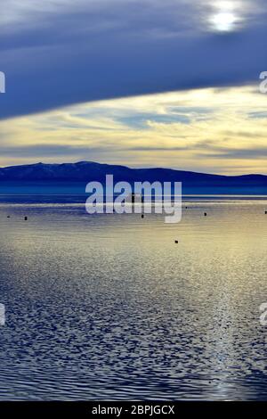 Sommeruntergang über dem ohridsee mit kleinem Boot. Stockfoto