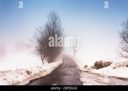 Schmelzender Schnee auf dem Berg Landstraße in den Karpaten. Wettervorhersage für frühen Frühling. Schwieriger Weg. Der frühe Frühling im gemäßigten Klima. Feder kom Stockfoto