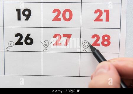 Ein Bleistift zeichnet lustige Leute auf einem Blatt ein Wandkalender Stockfoto