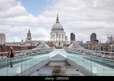 Blick Blick über die Millennium Bridge in Richtung St. Pauls Cathedral ist unheimlich ruhig und still, abgesehen von ein paar Fußgängern auf leeren Straßen, während die Blockierung andauert und die Menschen die Botschaft des Aufenthalts zu Hause in der Hauptstadt am 11. Mai 2020 in London, England, Großbritannien, beobachten. Coronavirus oder Covid-19 ist eine neue Atemwegserkrankung, die bisher beim Menschen nicht beobachtet wurde. Während ein Großteil oder Europa in die Blockierung gebracht wurde, hat die britische Regierung nun eine leichte Lockerung der strengen Regeln als Teil ihrer langfristigen Strategie angekündigt, insbesondere der sozialen Distanzierung. Stockfoto