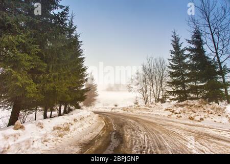 Schmelzender Schnee auf dem Berg Landstraße in den Karpaten. Wettervorhersage für frühen Frühling. Schwieriger Weg. Der frühe Frühling im gemäßigten Klima. Feder kom Stockfoto