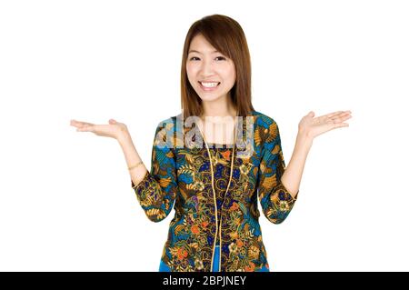 Southeast Asian Girl mit Batik kebaya Kleidung die Hand etwas zeigen, auf weißem Hintergrund stehen. Stockfoto