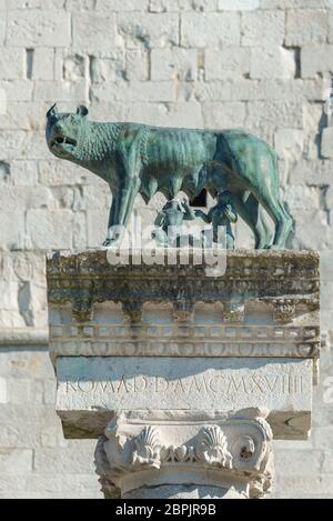 Skulptur von Romulus und Remus, gesaugt von einer Wölfin. Vor dem Glockenturm der Patriarchalbasilika von Aquileia, einem antiken römischen C. Stockfoto
