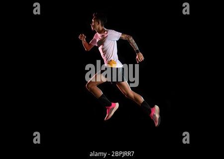 Asian Mann junge Sprinter Läufer läuft im Studio auf schwarzem Hintergrund Stockfoto