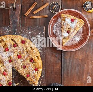 Apfelkuchen auf einem rechteckigen alte braune Schneidbrett bestreut mit Puderzucker, Ansicht von oben Stockfoto