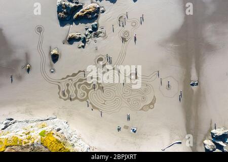 Bandon by the Sea, Oregon / USA - März 07 2020: Das Team von Circles in the Sand zeichnet ein begehbares Labyrinth im flachen Sandstrand von Face Rock Sta Stockfoto