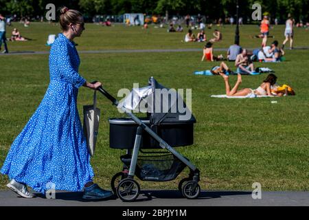 London, Großbritannien. Mai 2020. Die Menschen genießen die Sonne auf Clapham Common, nachdem die Regierung die Beschränkungen gelockert und den Menschen erlaubt hat, sich zu treffen - Lambeth Council hat die Schilder ersetzt, die sagen, wachsam zu bleiben und den Menschen zu erlauben, auf Bänken zu sitzen. Die "Lockdown" geht weiter für den Ausbruch des Coronavirus (Covid 19) in London. Kredit: Guy Bell/Alamy Live News Stockfoto