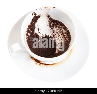 Divination auf Kaffeesatz - weißes Porzellan Tasse mit Kaffee Sedimente auf Untertasse auf weißem Hintergrund Stockfoto