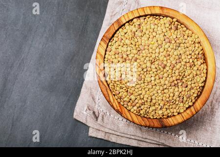 Roh Linsen auf Schwarz Stein Hintergrund. Gesunde vegetarische Essen Konzept. Superfoods. Ansicht von oben, kopieren. Linsen sind reich an komplexen Kohlenhydraten, f Stockfoto