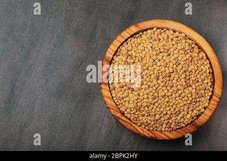 Roh Linsen auf Schwarz Stein Hintergrund. Gesunde vegetarische Essen Konzept. Superfoods. Ansicht von oben, kopieren. Linsen sind reich an komplexen Kohlenhydraten, f Stockfoto