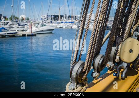 Auf der alten Segelboot vor dem Hintergrund der modernen Yachten Rigging Stockfoto