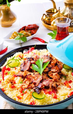Tajin mit Couscous, Gemüse und Fleisch auf weißem Hintergrund Stockfoto