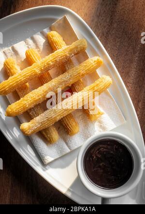 Churros con chocolate Traditionelle spanische süßes Frühstück auf hölzernen Tisch Set Stockfoto