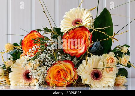 Fragment eines Straußes von Rosen und Gerberas, die auf dem Tisch liegen Stockfoto