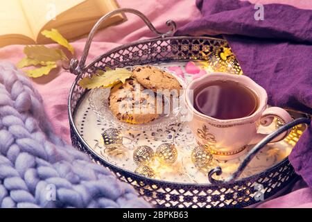 Rosa Tasse Tee, Plätzchen, Garland und Wolldecke Stockfoto