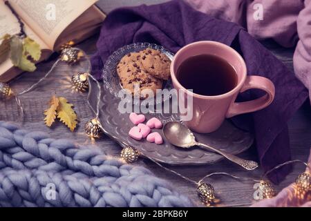 Rosa Tasse Tee, Plätzchen, Garland und Wolldecke Stockfoto