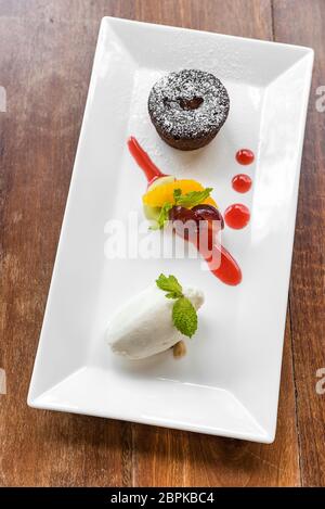 Schokoladen-Fondant-Lava-Kuchen mit Eis und frischen Früchten Stockfoto