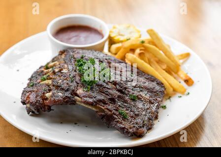 Vom Grill gegrillte Baby wieder Schweinerippchen mit gegrilltem Mais und Pommes frites Stockfoto