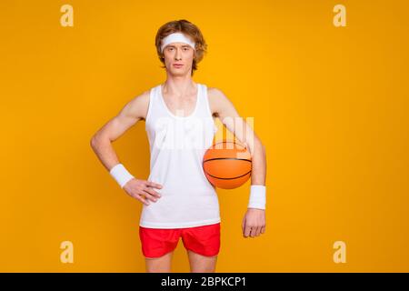 Porträt von seinem er schön attraktiv schlank funky Inhalt ernst Kerl Sportler hält in der Hand orange Ball isoliert über helle lebendige Glanz lebendig Stockfoto