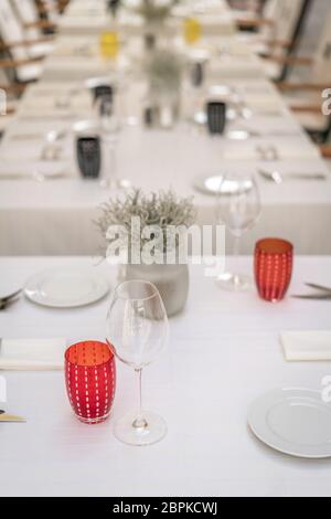 Wein, Gläser, Teller und Besteck auf dem Tisch vor dem Start des Service im Restaurant Stockfoto
