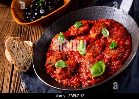 Gebackene mini Hackbällchen in Tomatensauce mit Basilikum Stockfoto