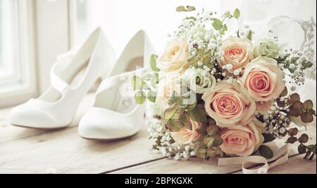 Bräute weiße Schuhe und schöne Hochzeit bridal Bouquet von Rosen in Nahaufnahme auf Holz- Schwelle hellen Fenster Stockfoto