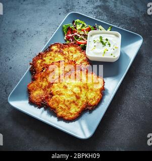 Frittierte Deutsch Kartoffelpuffer mit cremig Dip auf einer Schüssel für einen leckeren Aperitif in einem hohen Winkel serviert Stockfoto