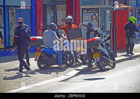 London, Großbritannien. Mai 2020. Roller Lieferung Fahrer nicht zu halten sozialen Distanzierung. Coronavirus Social Distancing Warteschlangen bei der Post Tooting. Kredit: JOHNNY ARMSTEAD/Alamy Live News Stockfoto