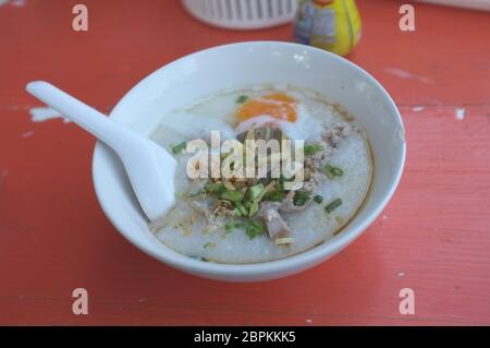 Reis Suppe oder Congee Schweinehack und Innereien mit Ei an Witz kun pa Restaurants in Amphoe Pak Chong, Korat, Thailand Stockfoto