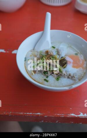 Reis Suppe oder Congee Schweinehack und Innereien mit Ei an Witz kun pa Restaurants in Amphoe Pak Chong, Korat, Thailand Stockfoto