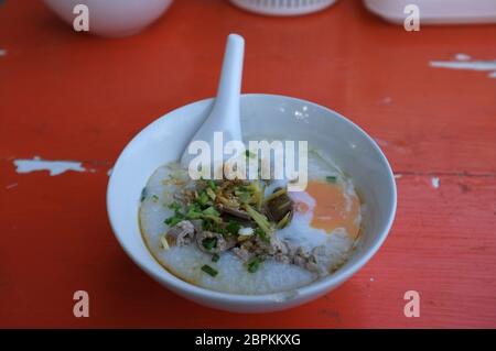 Reis Suppe oder Congee Schweinehack und Innereien mit Ei an Witz kun pa Restaurants in Amphoe Pak Chong, Korat, Thailand Stockfoto