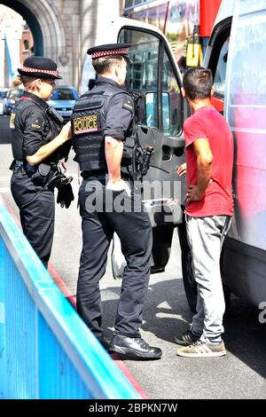 City of London zwei Polizisten in Uniform im Gespräch mit männlichen Insassen von weißen Van hielten in der Straße auf Tower Bridge Southwark London England Großbritannien Stockfoto